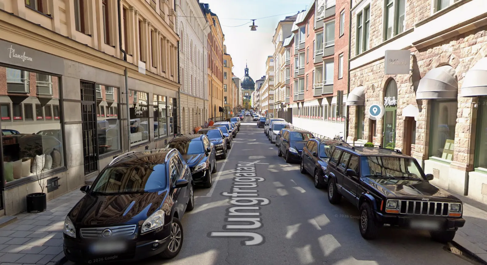 Jungfrugatan på Östermalm idag: parkerade bilar längs båda trottoarkanterna.