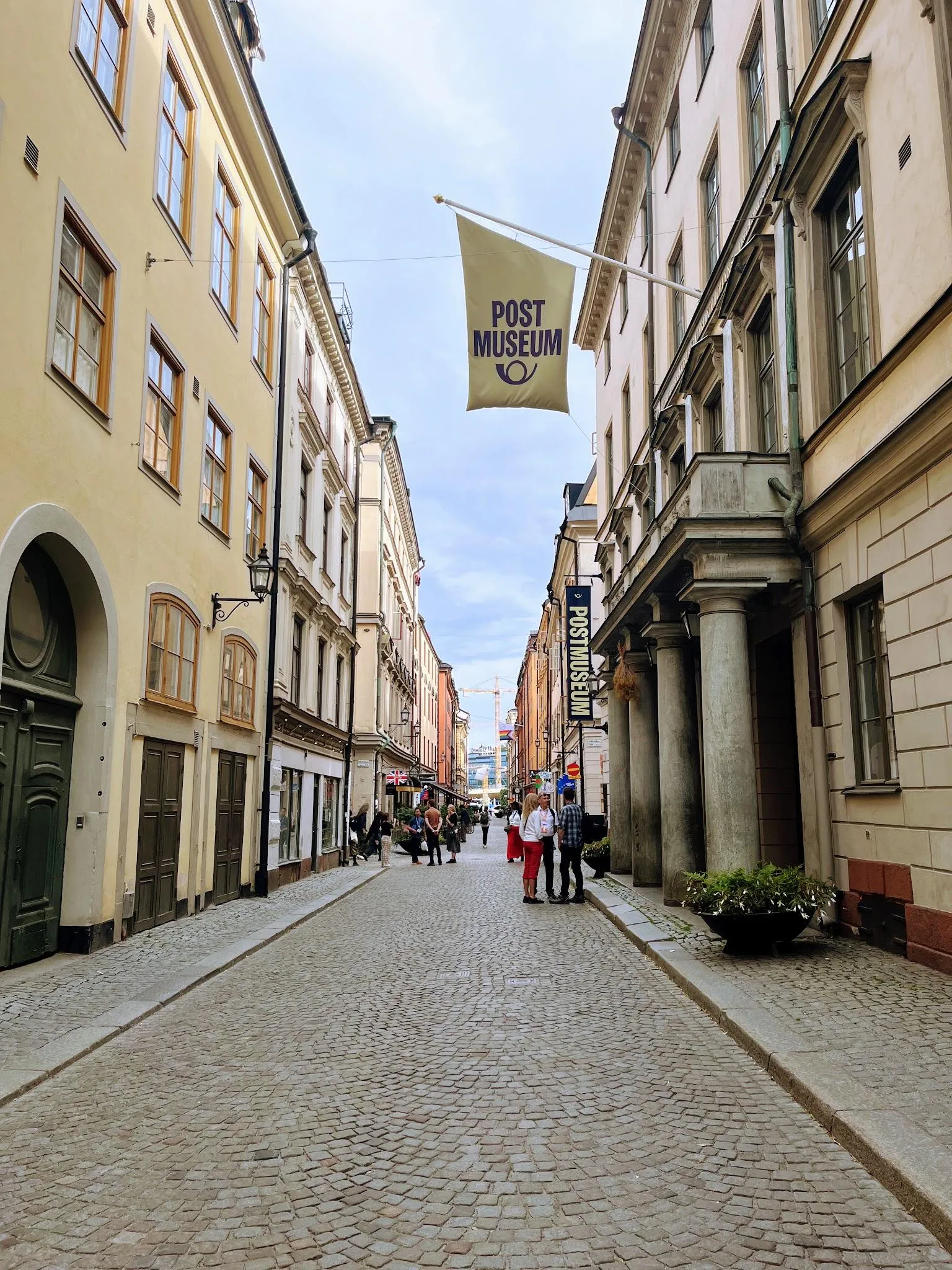 Lilla Nygatan i Gamla stan: en kullerstensbelagd bilfri gata där människor strosar mellan gamla stans fasader.